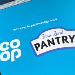 A blue bunting flag with the Coop and Your Local Pantry logos