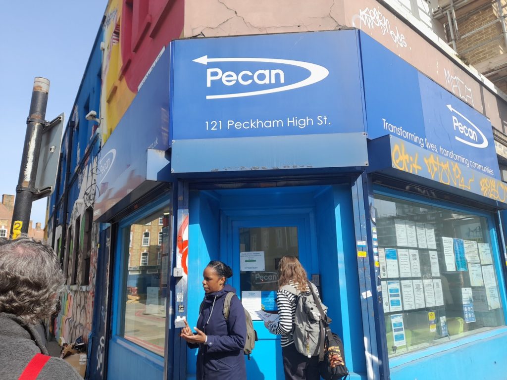 The Pecan office: a corner high street building decorated blue, with a Pecan sign above the door.