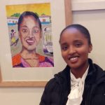 Sandra in front of her portrait.