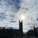 The tall tower of St Mary's Church against a slightly cloudy sky, with the sun breaking through