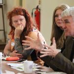 RIchard Andrew speaks, while seated beside two members of Thriving Women