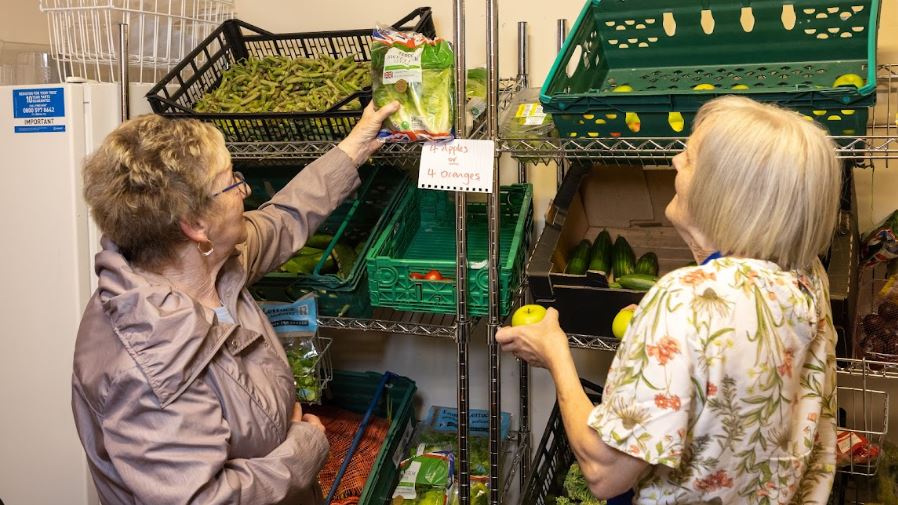 A member reaches for a bag of salad at Hope Pantry in Merthyr Tydfil