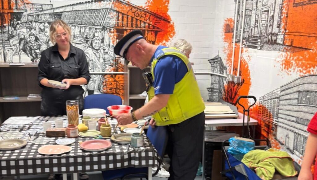 A local police officer joins in with the plate-making activity.