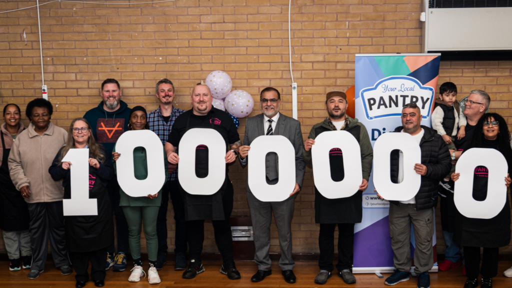 A line of people holding cardboard numbers reading 1,000,000
