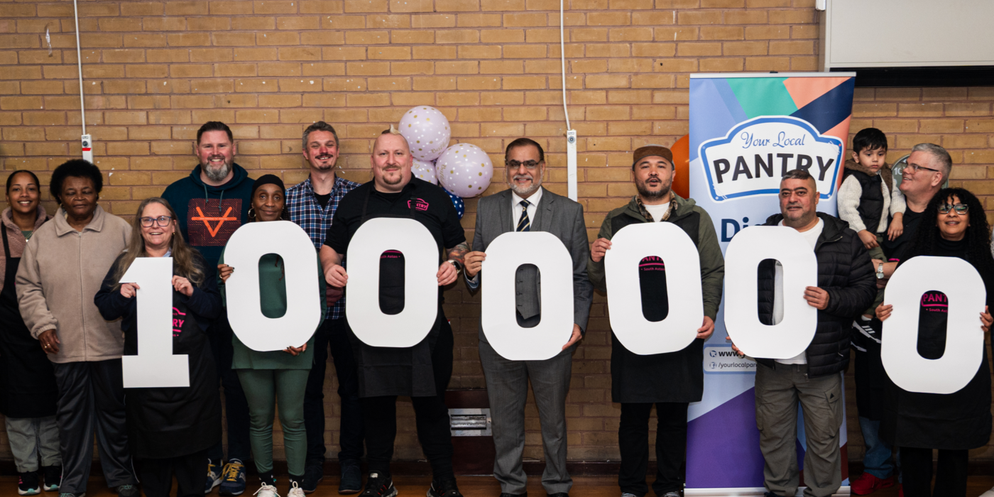 A line of people holding cardboard numbers reading 1,000,000