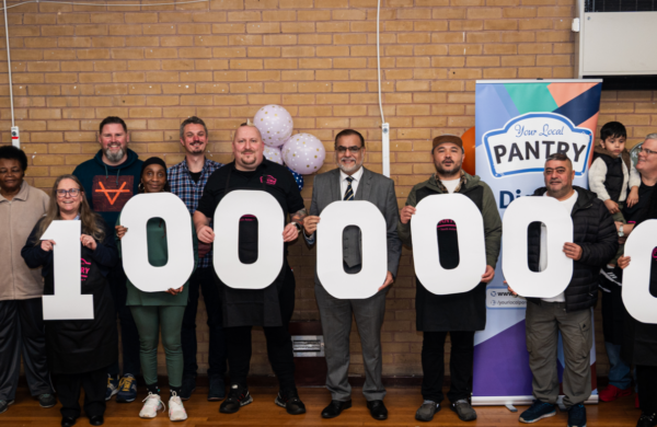 A line of people holding cardboard numbers reading 1,000,000
