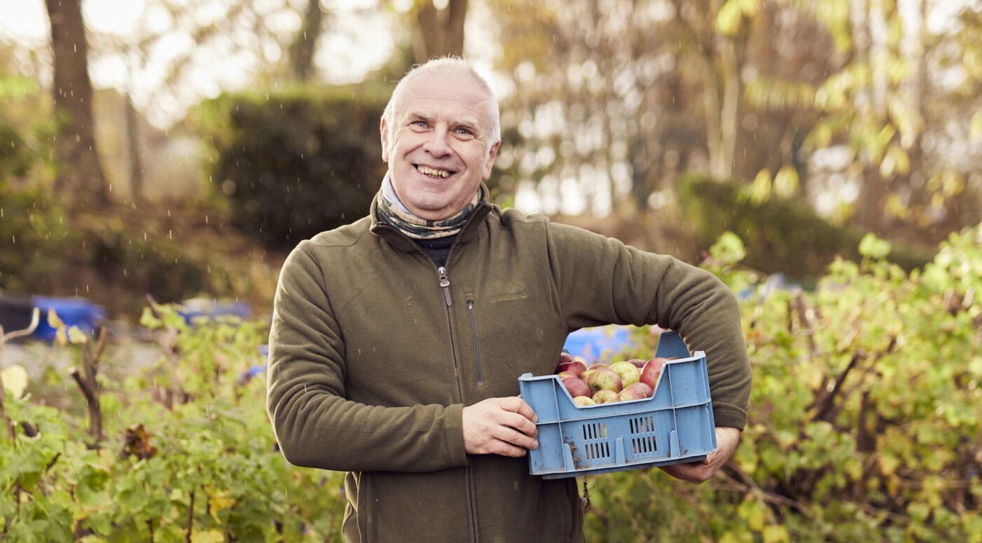 Nick Waterfield outdoors, holding a crate of apples